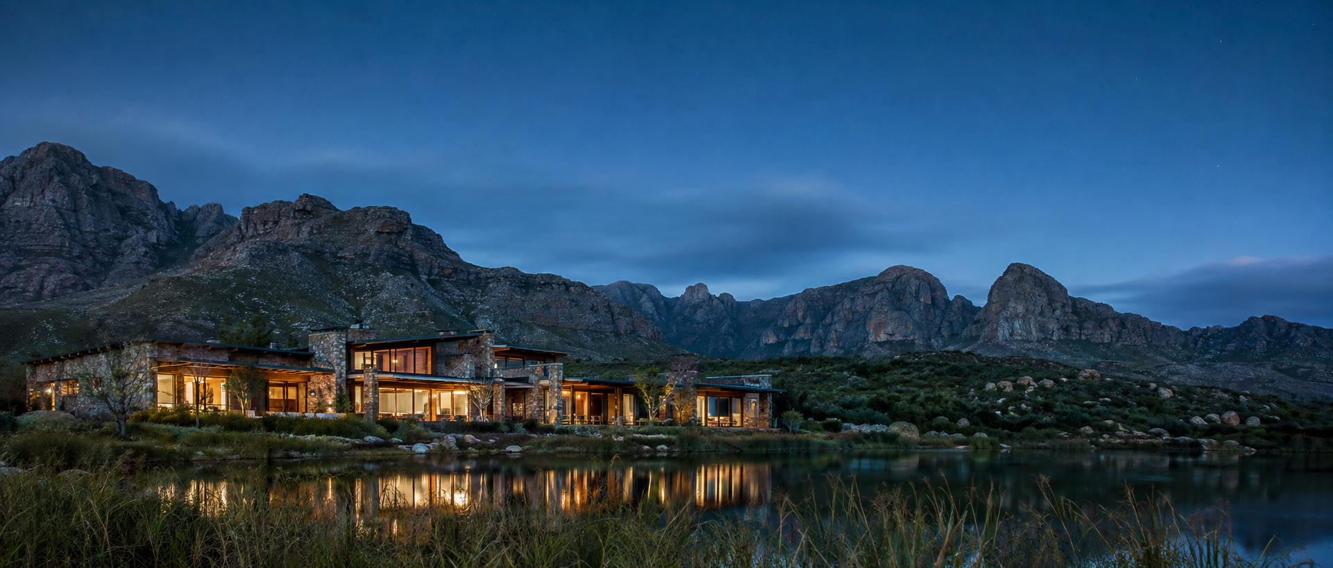 Imagined stone and timber lodge on a mountain lake at dusk